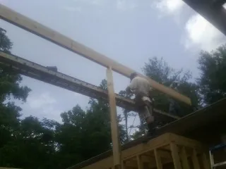 Carpenter setting a ridge beam over a new addition frame — Ice Dam Removal by Roofing Brothers in Oregon
