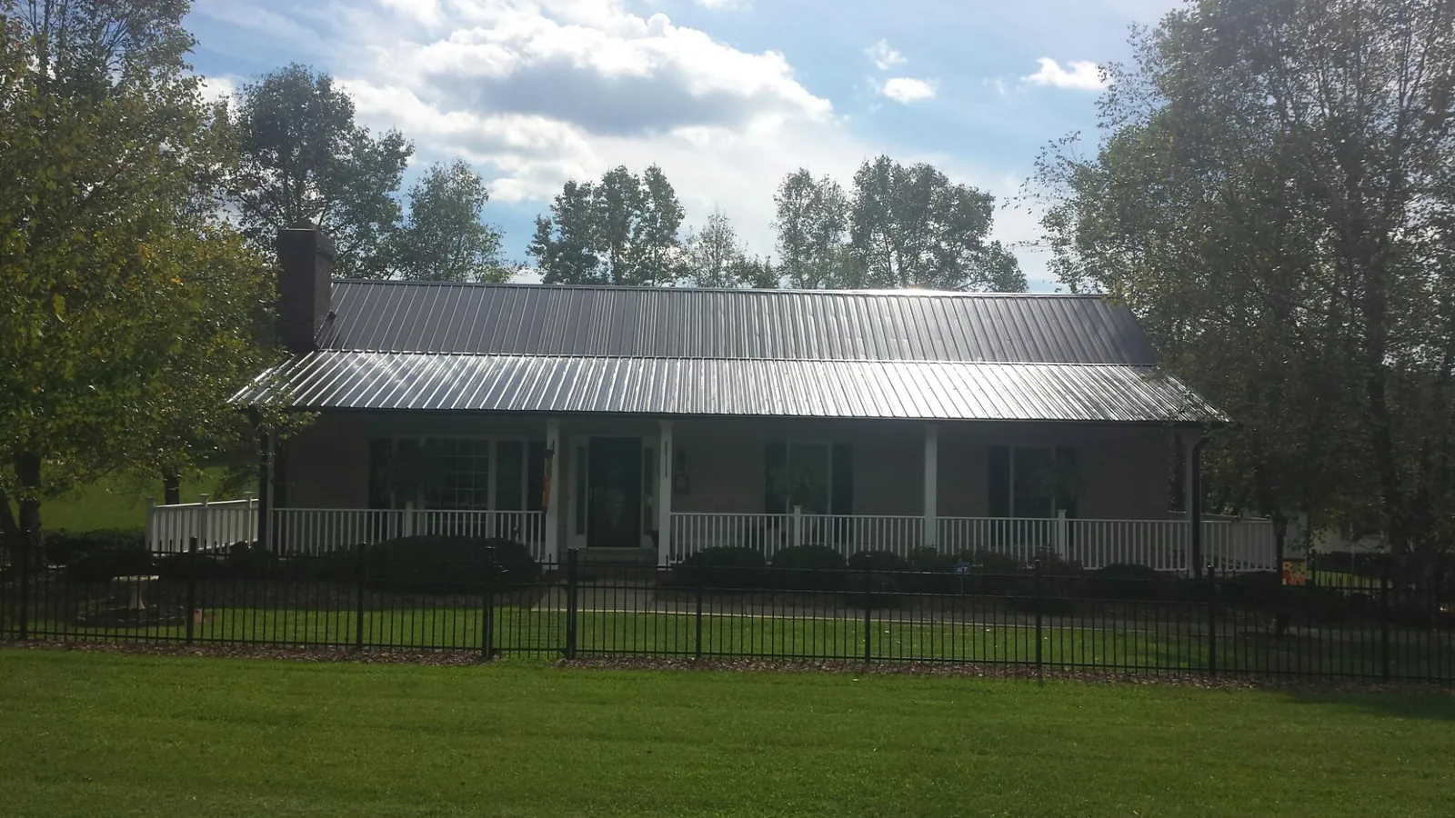 Gray metal roof on a brick ranch with a full width front porch — Gutter Guard Installation work by our crew in Oregon